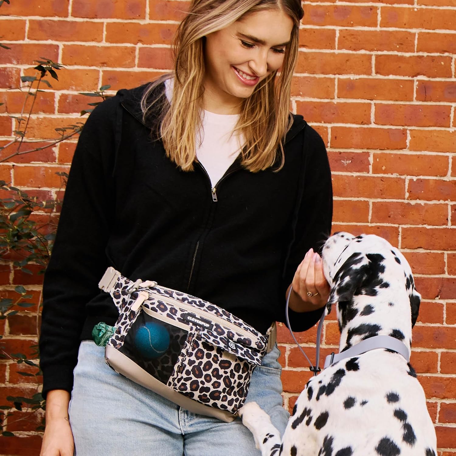 dog and woman wearing leopard bag