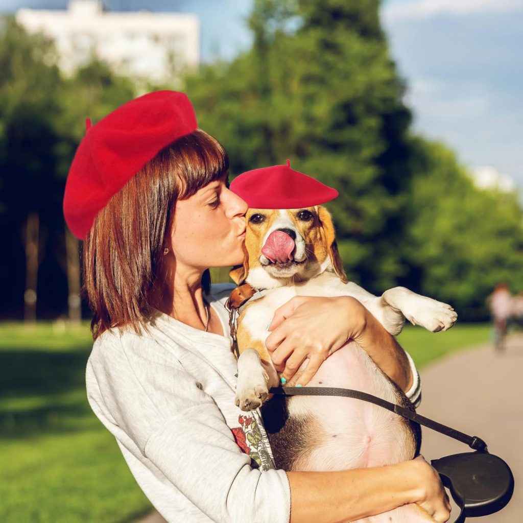 woman and dog wearing red berets