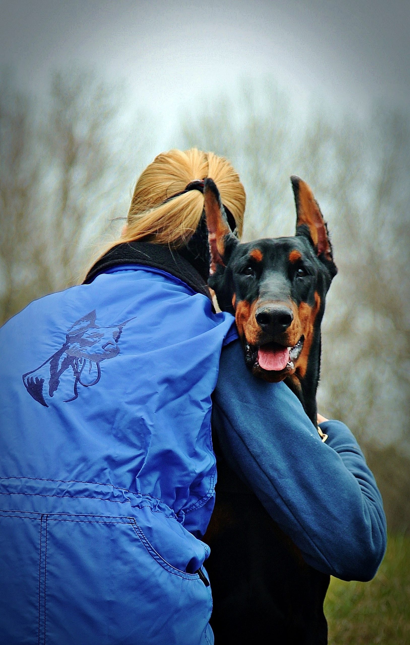 woman hugging doberman